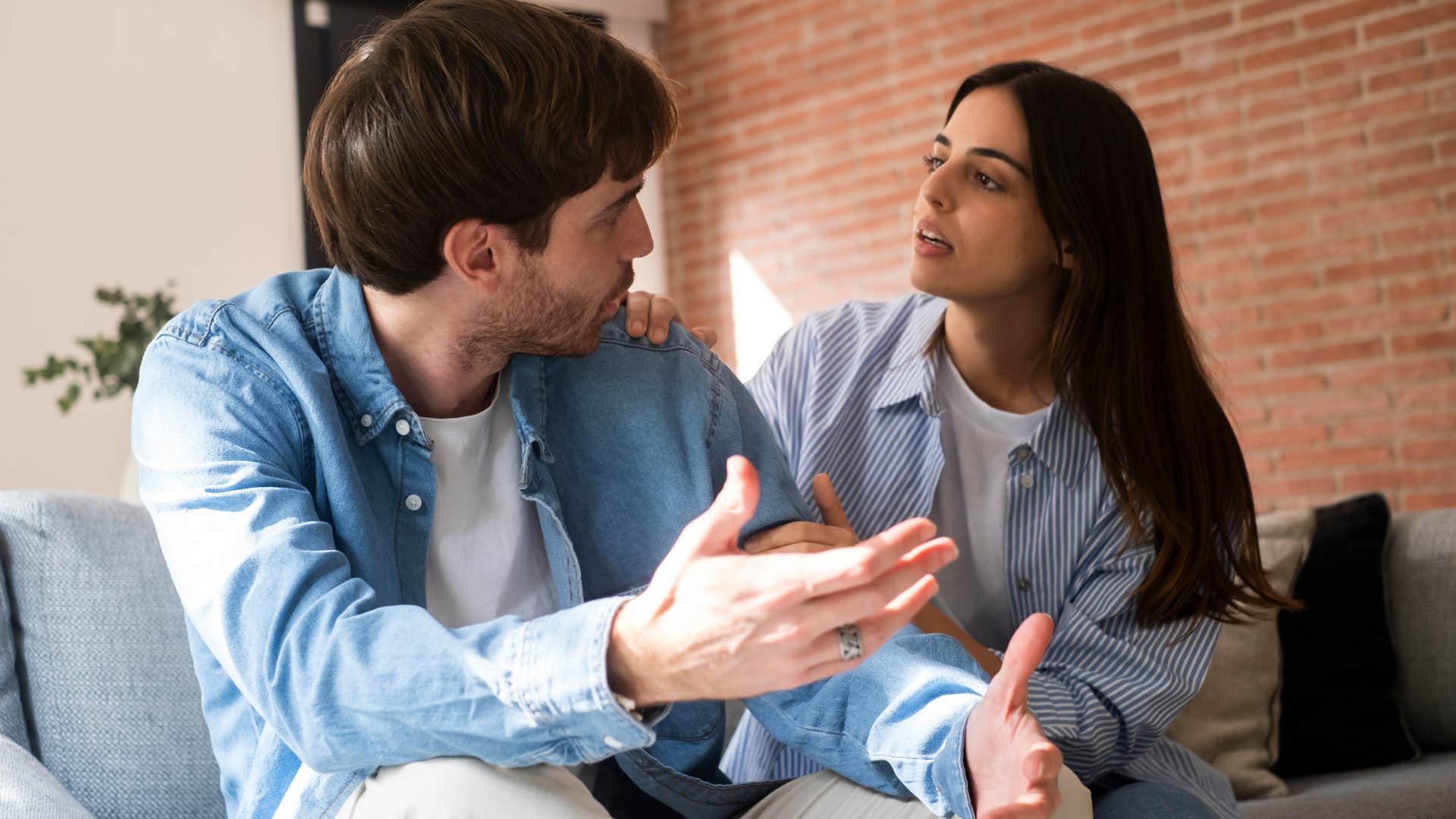 Couple arguing on a couch.