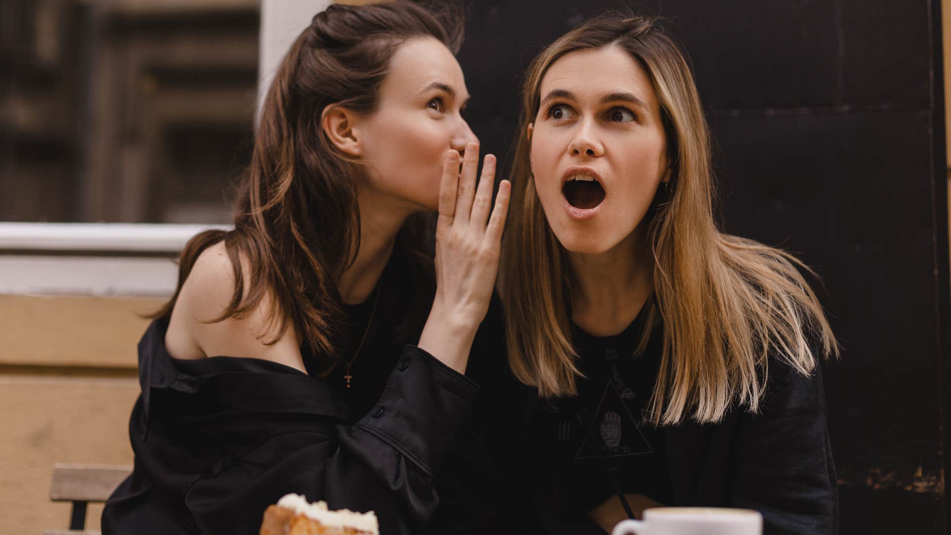 Two women gossiping with each other.