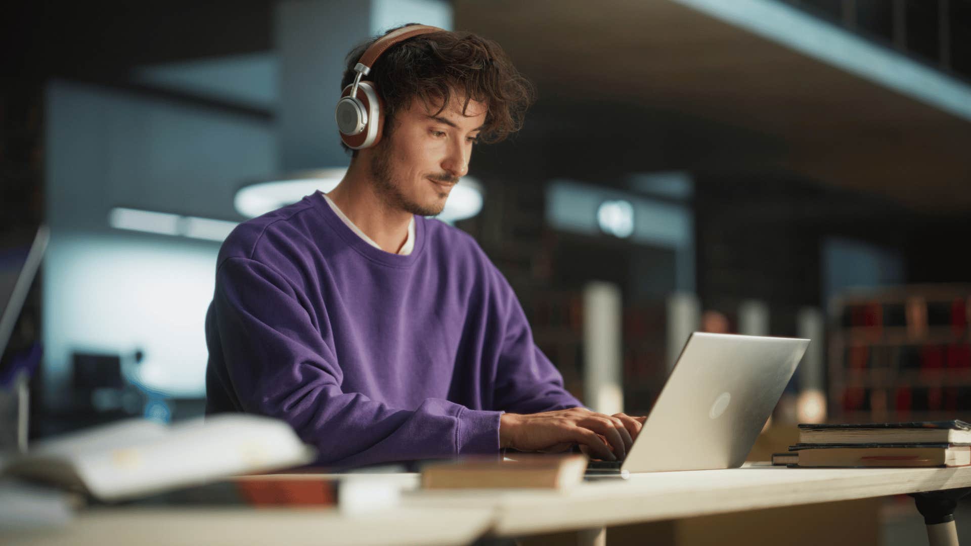 man working on laptop with headphones in