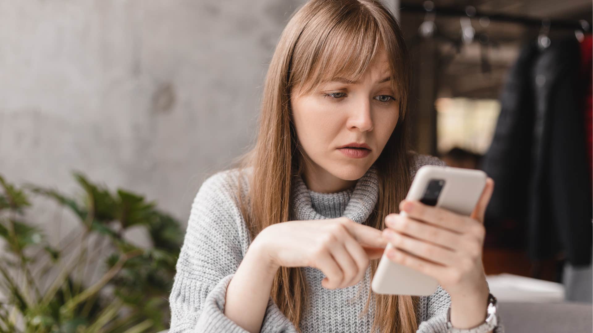 Woman looking confused staring at her phone