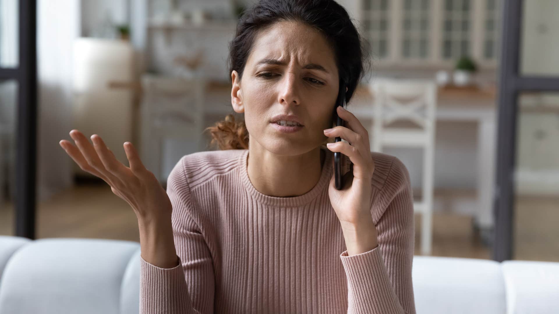 Adult woman looking annoyed while talking on the phone