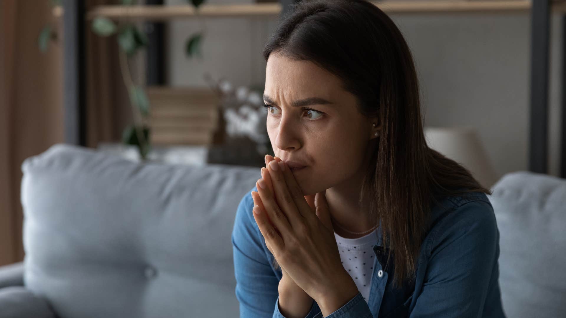 Woman looking indecisive on her couch