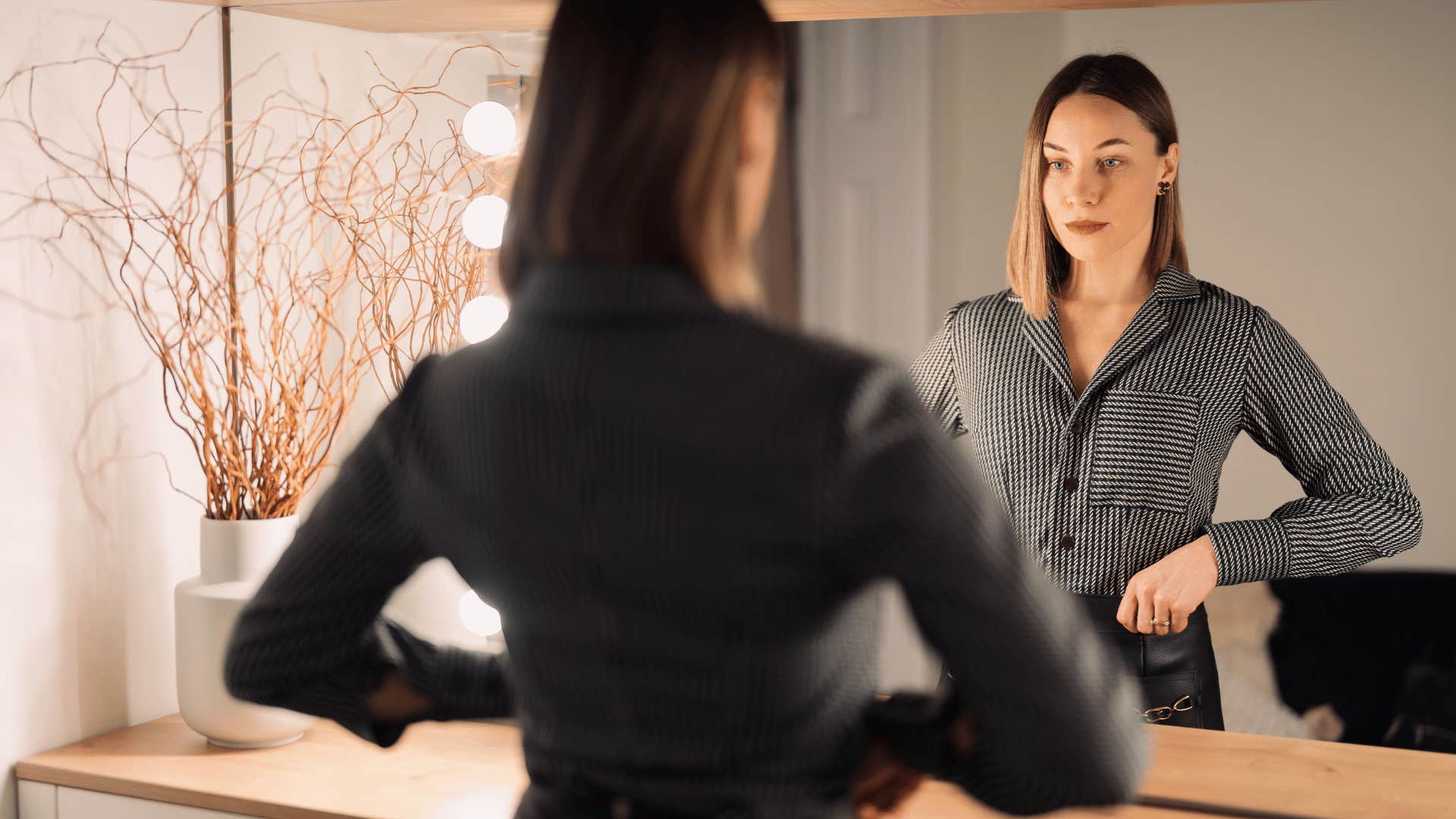 woman checking herself in the mirror 