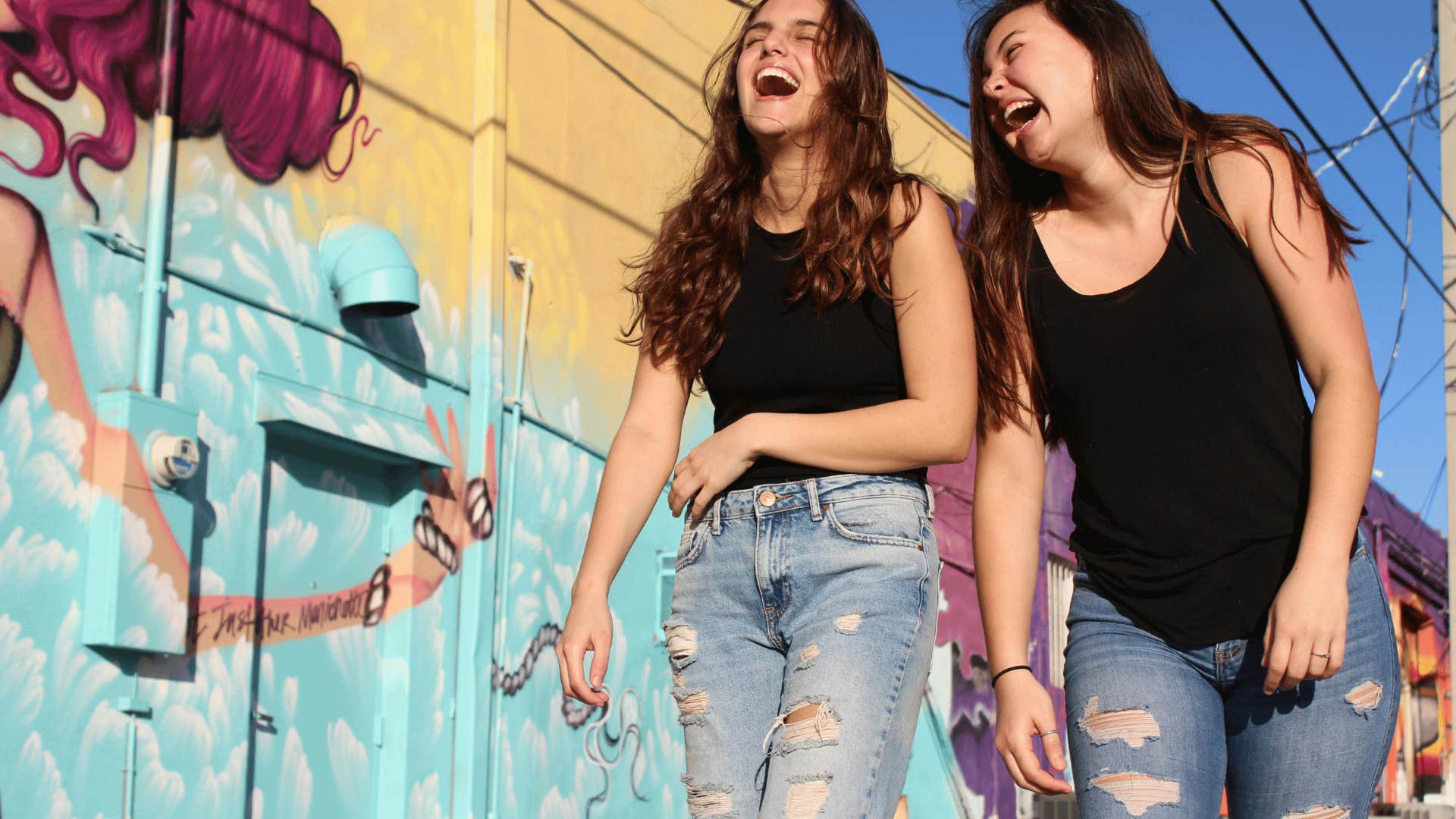 two girls laughing and walking