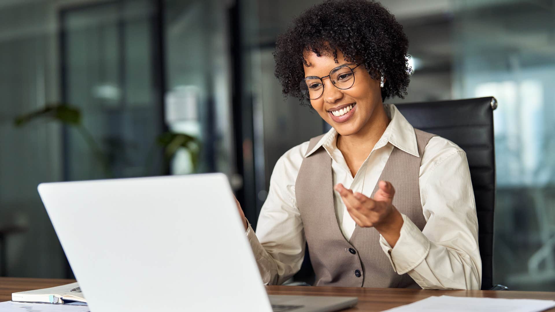 Woman smiling and talking at her laptop.