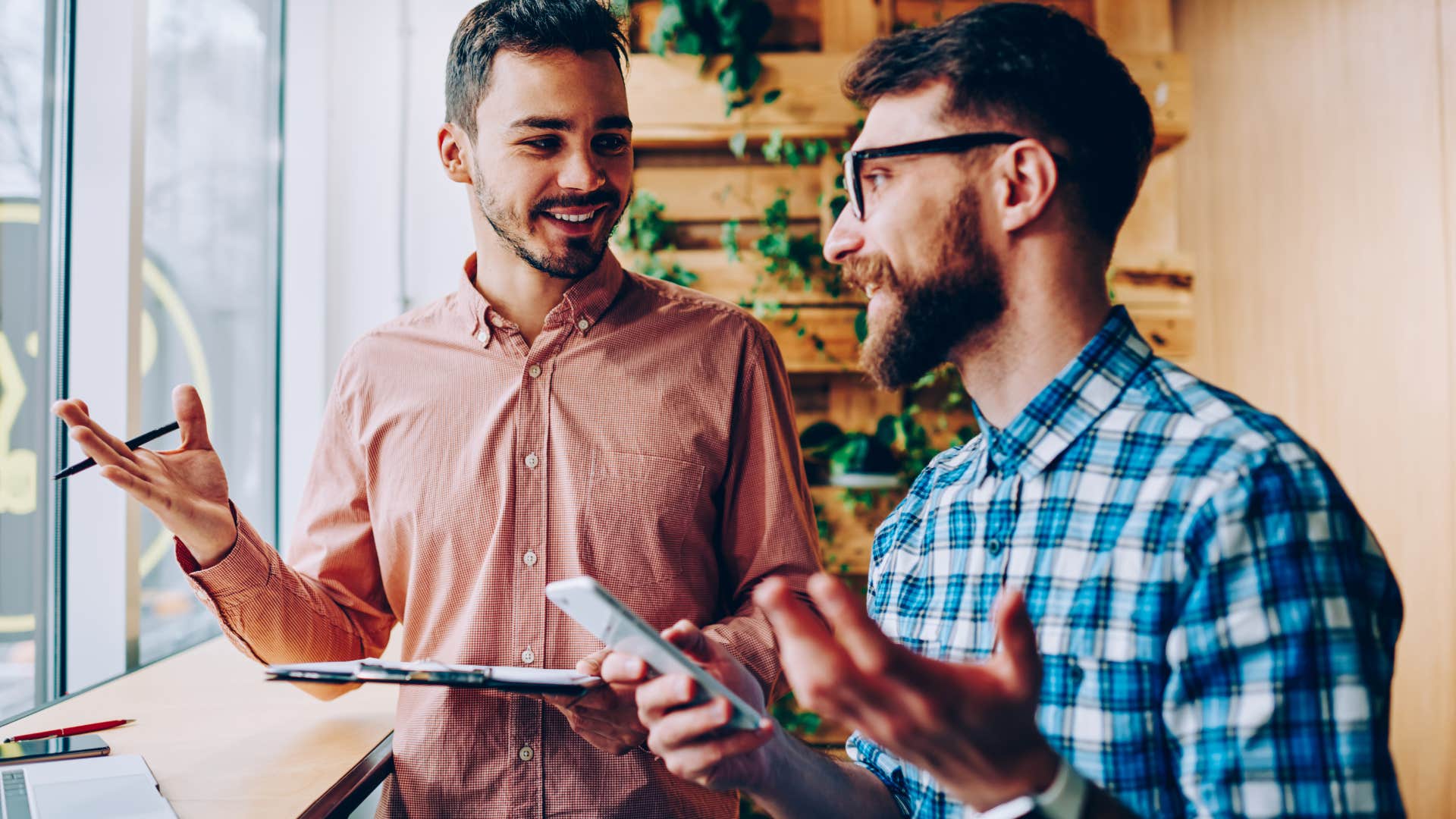 Two men smiling and talking together.