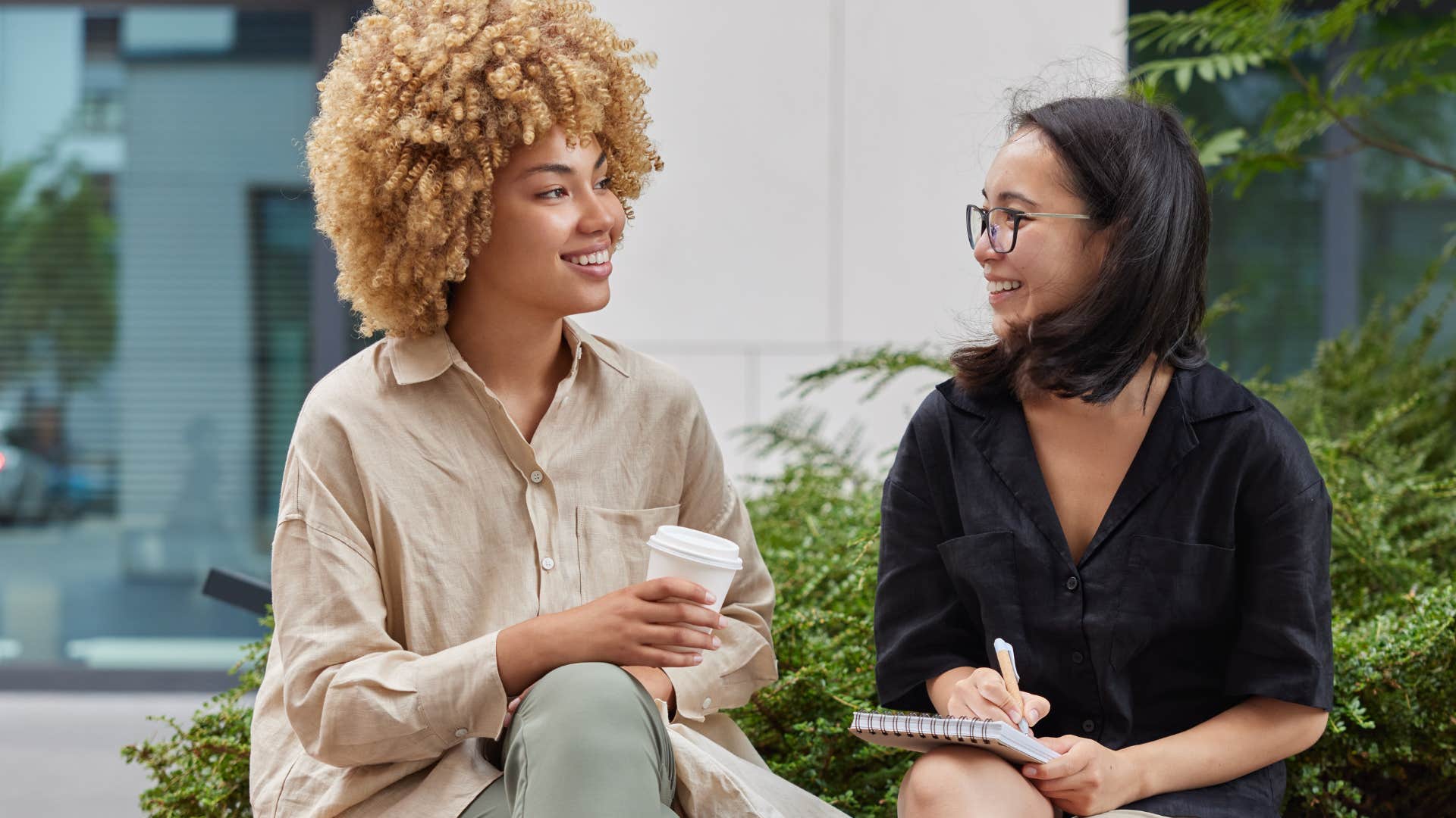 Two women smiling and talking to each other.