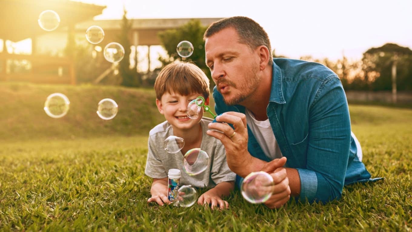 dad blowing bubbles with son