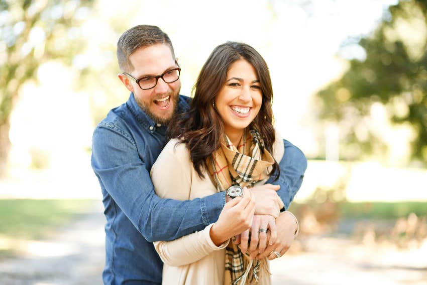 man hugging woman from behind