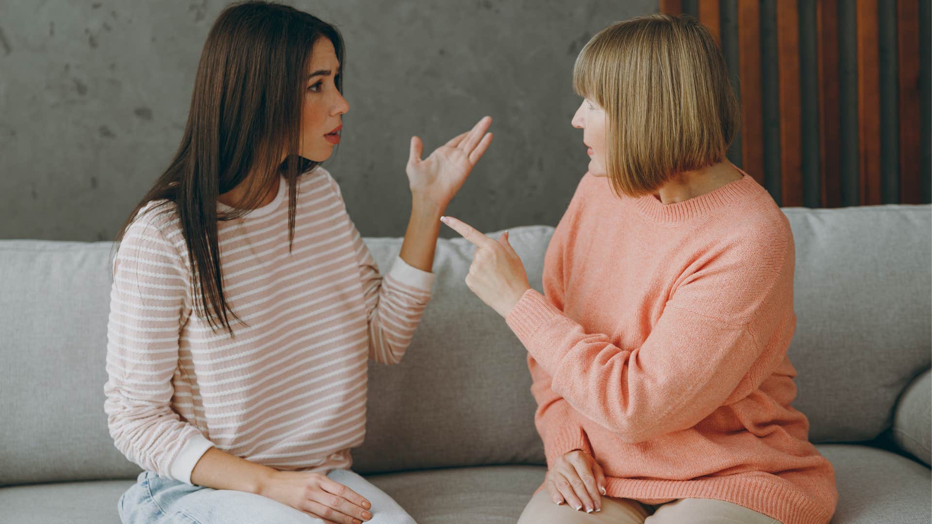 Woman and her mother arguing on a couch.