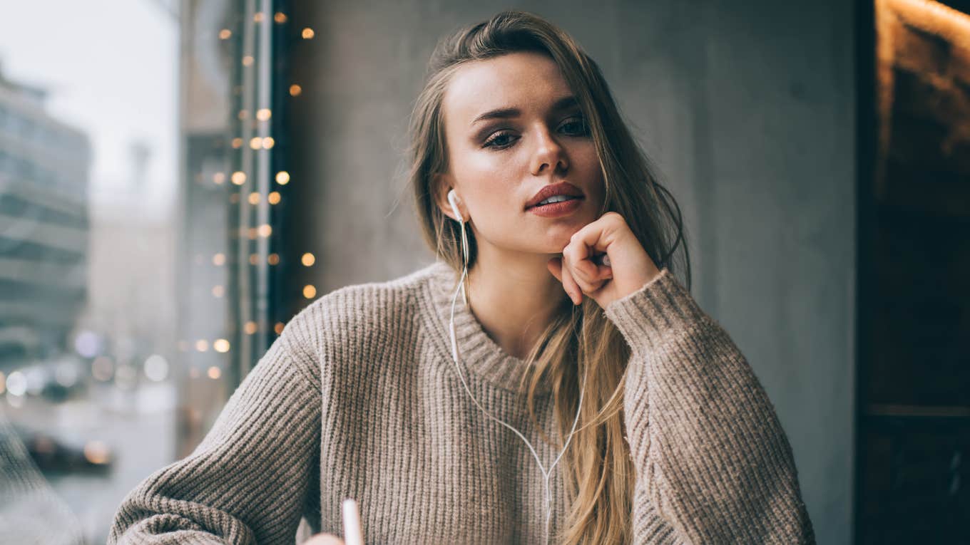 Smart and thoughtful woman in casual wear and earphones