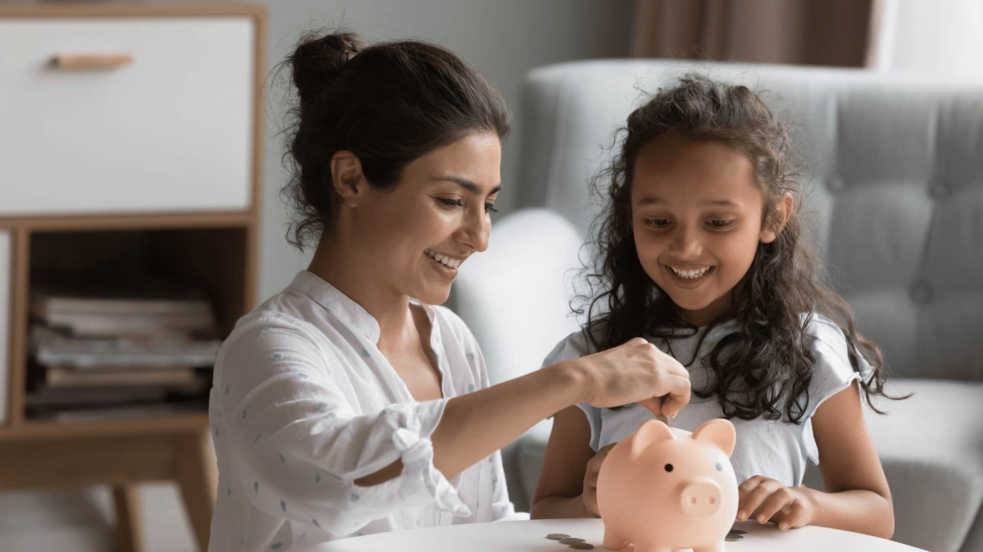 young girl saving money with her mom