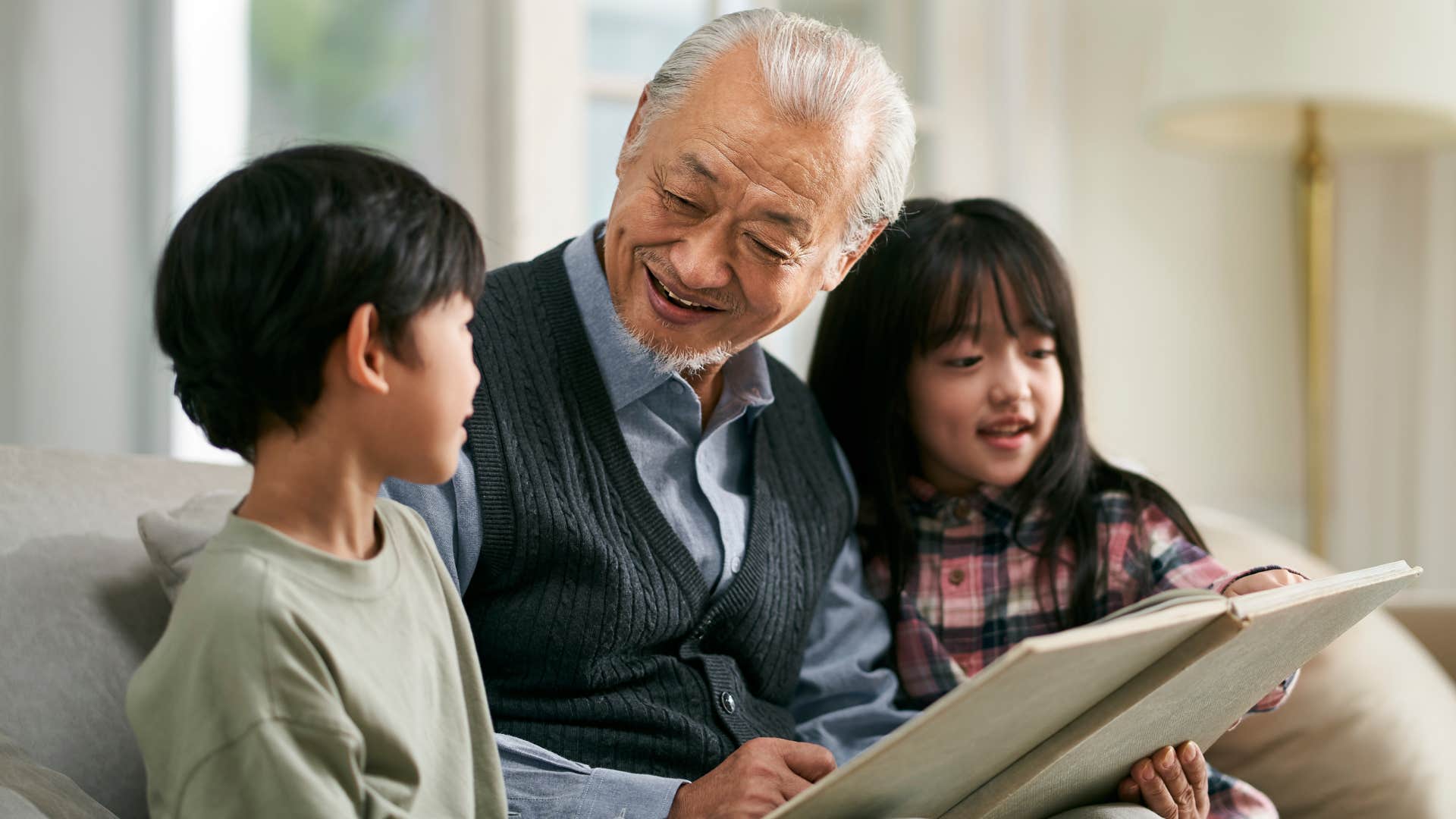 Grandpa reading to his two young grandchildren