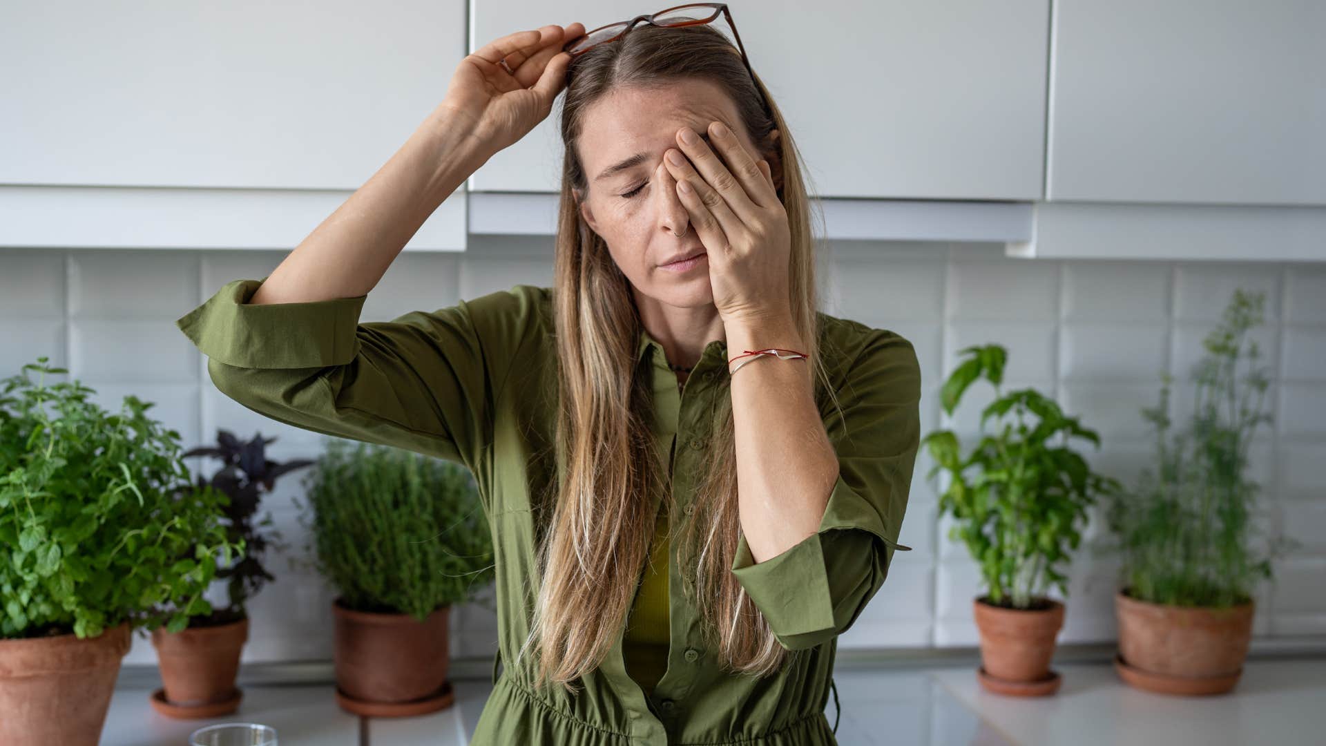 Gen X woman looking stressed standing in her kitchen