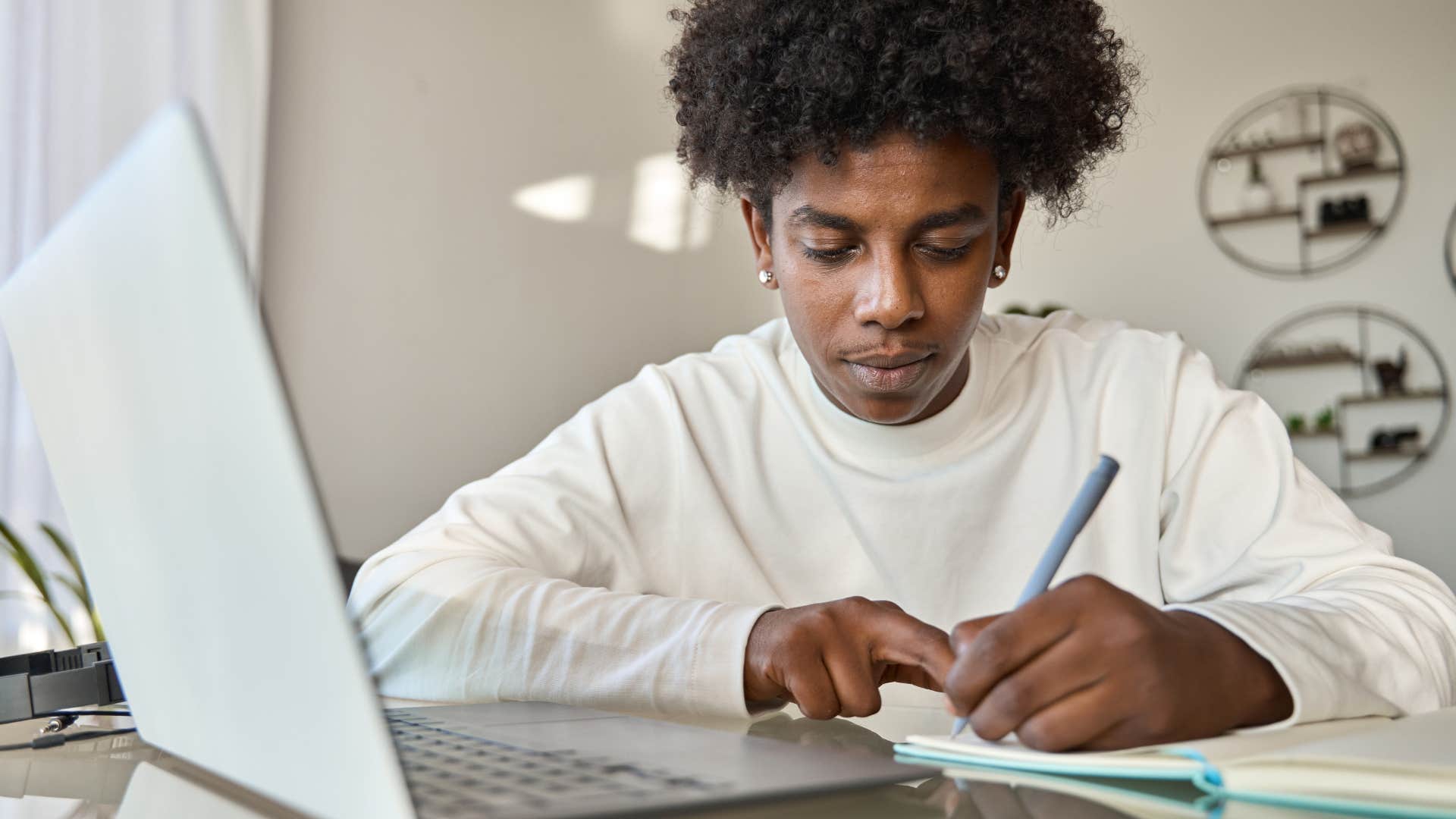 Gen Z student writing on a piece of paper on his desk