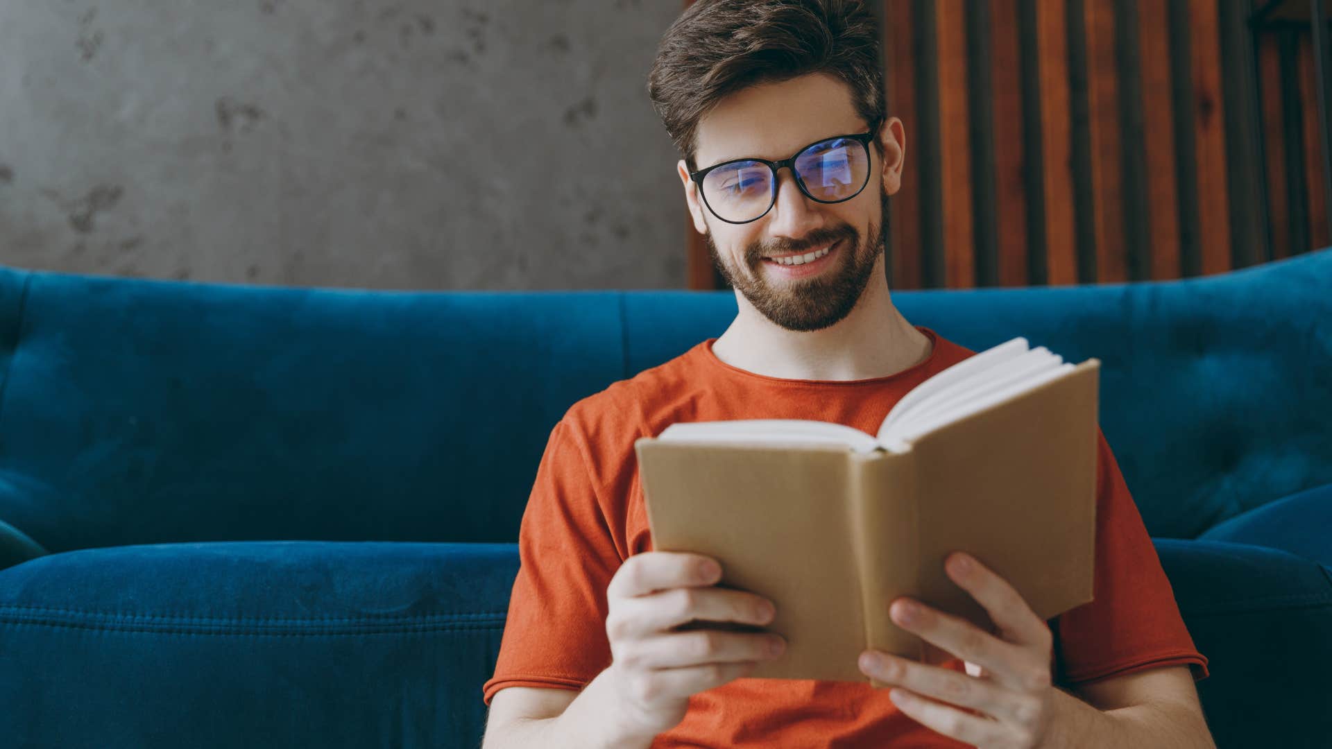 Man smiling and reading a book