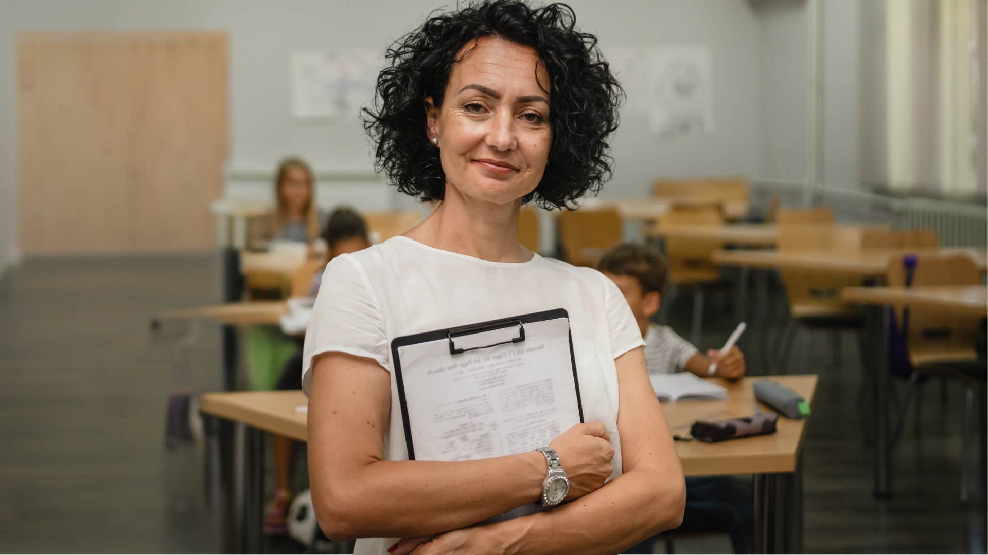 Teacher smiling at the front of her classroom