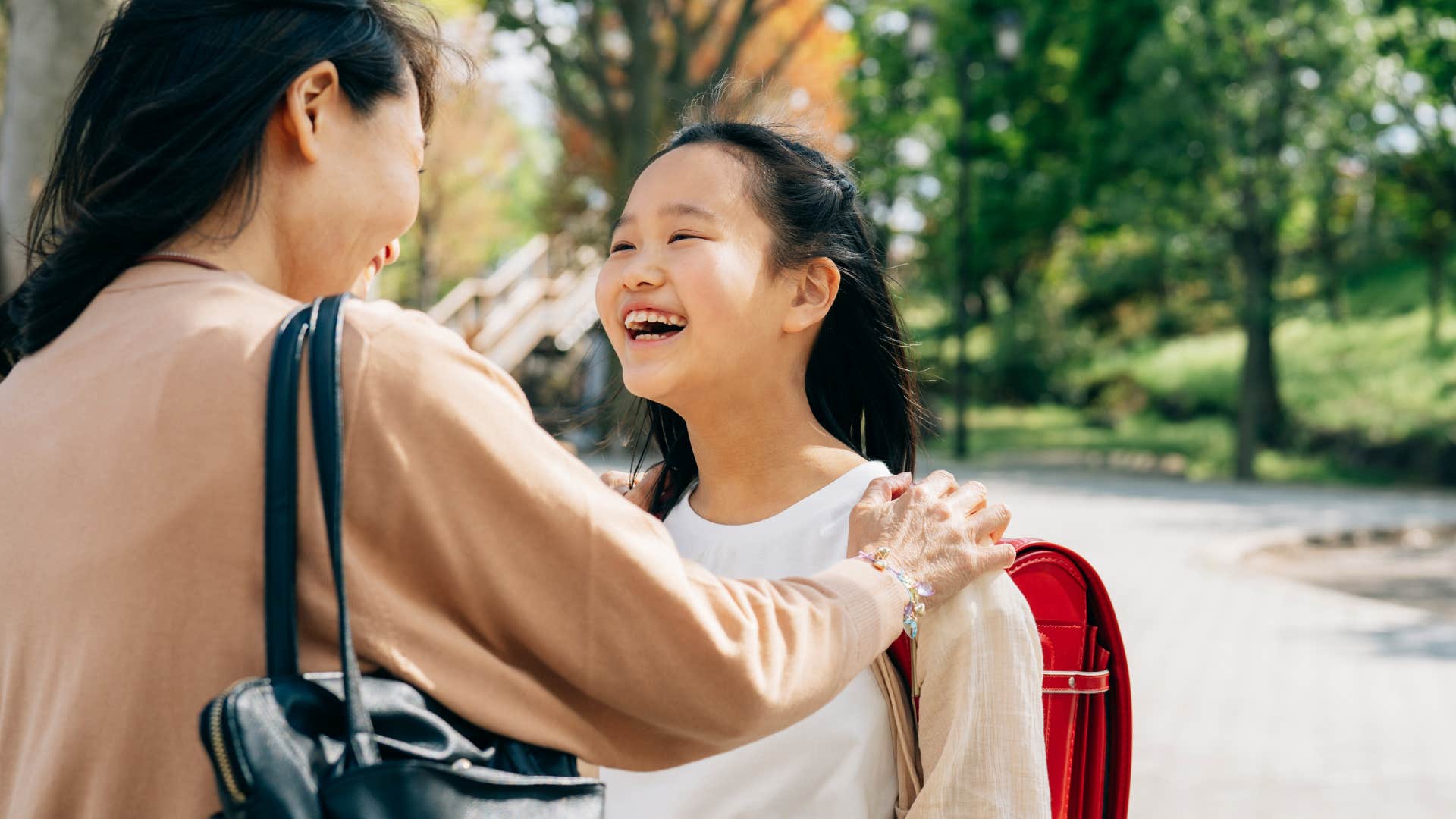 Woman smiling and comforting her happy daughter