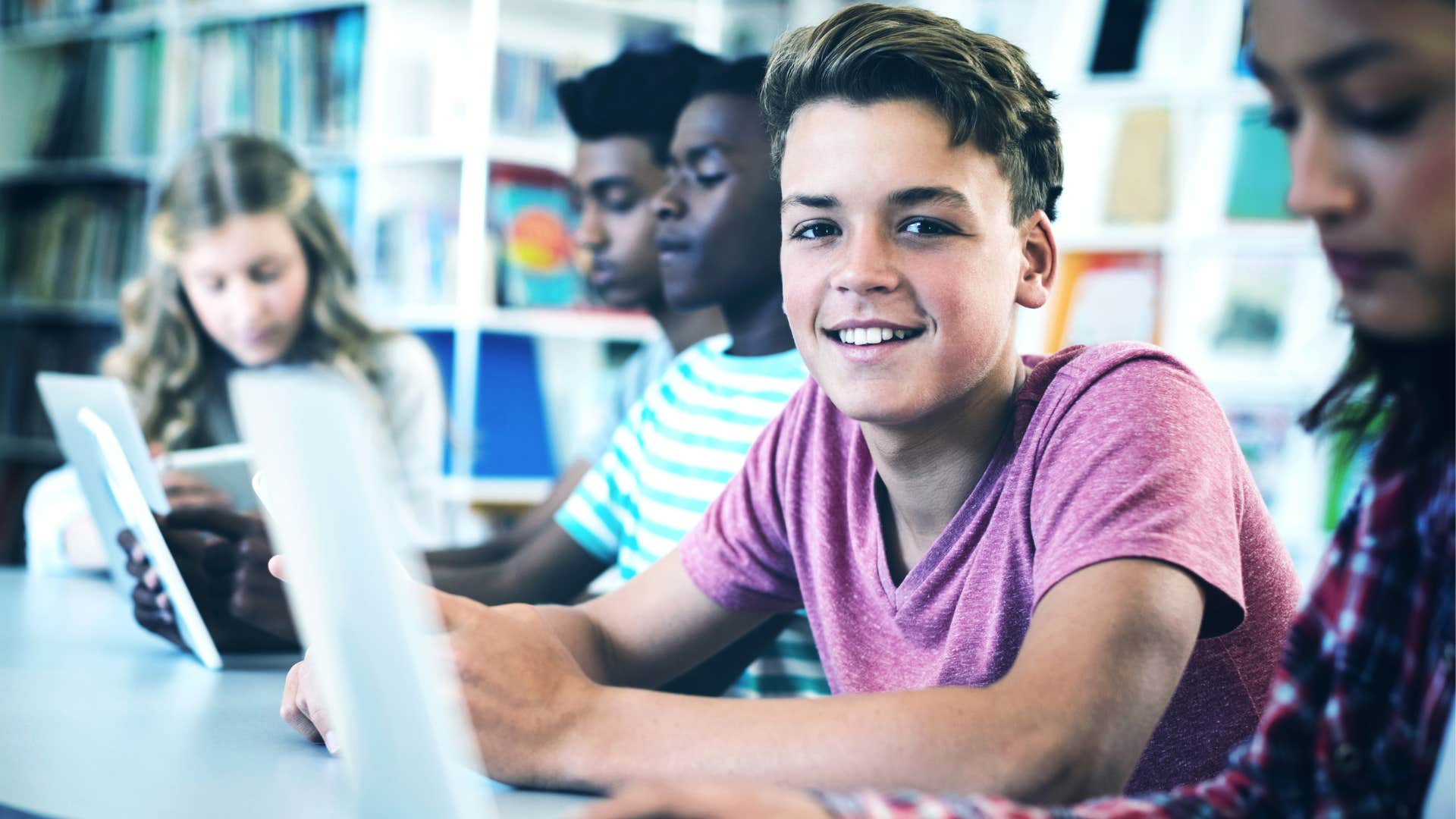 Young male student smiling at his desk