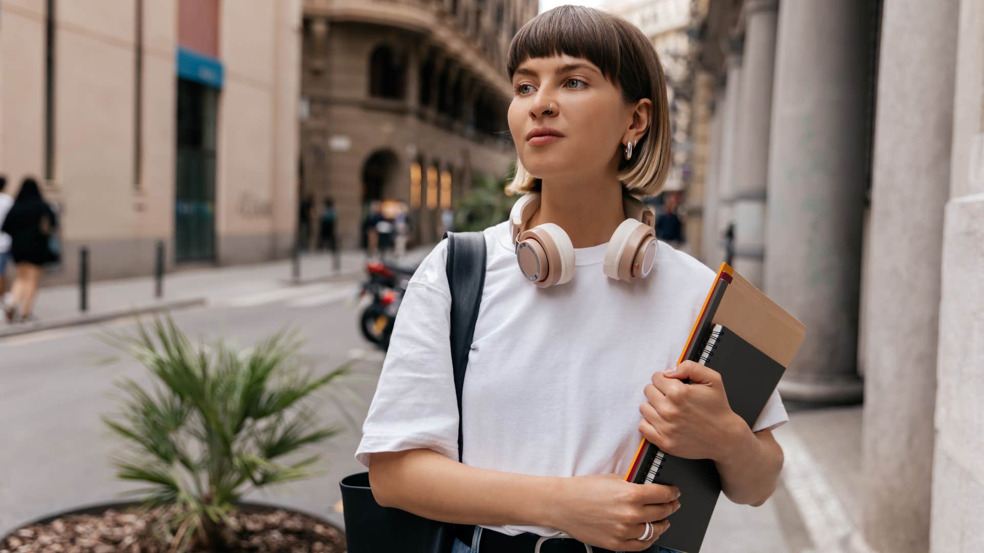 Gen Z woman smiling and walking down the street.