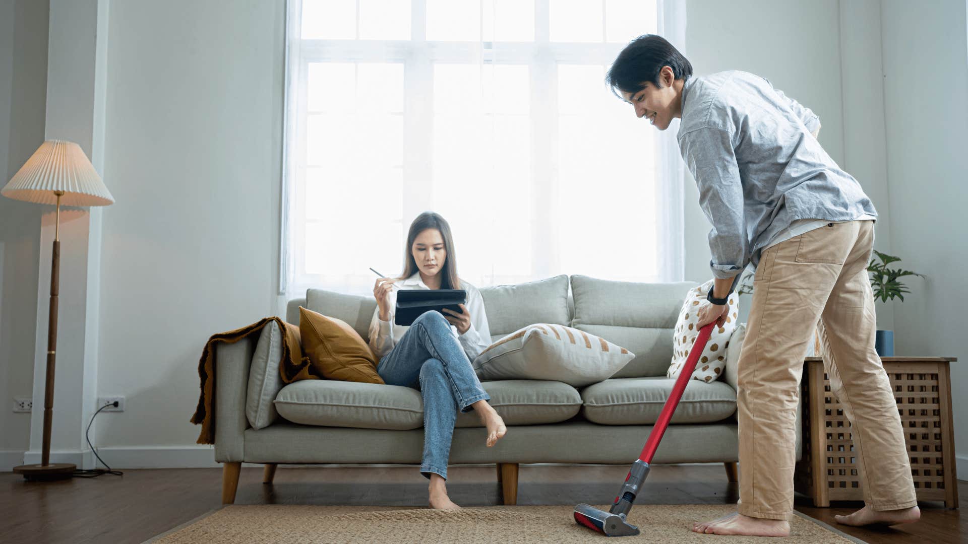 man cleaning around woman