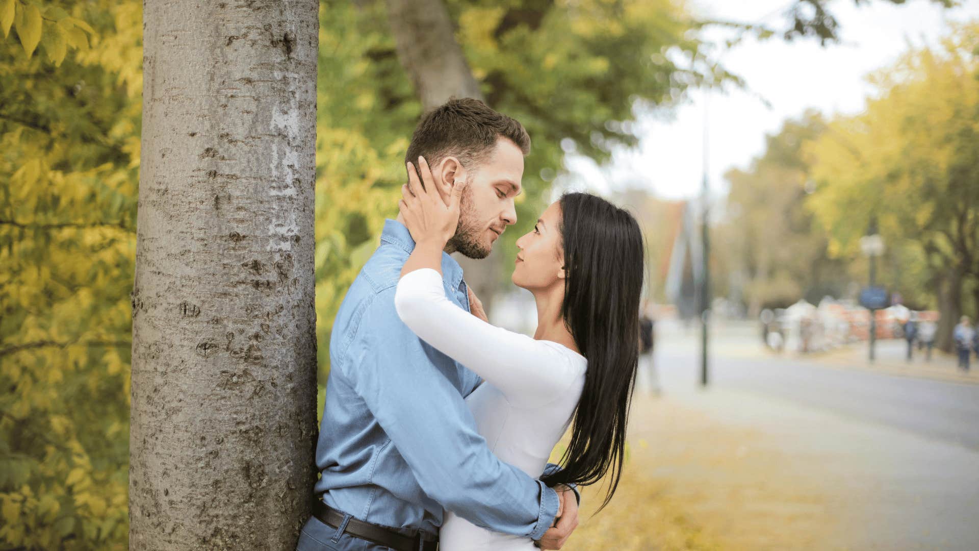 woman and man hugging next to tree