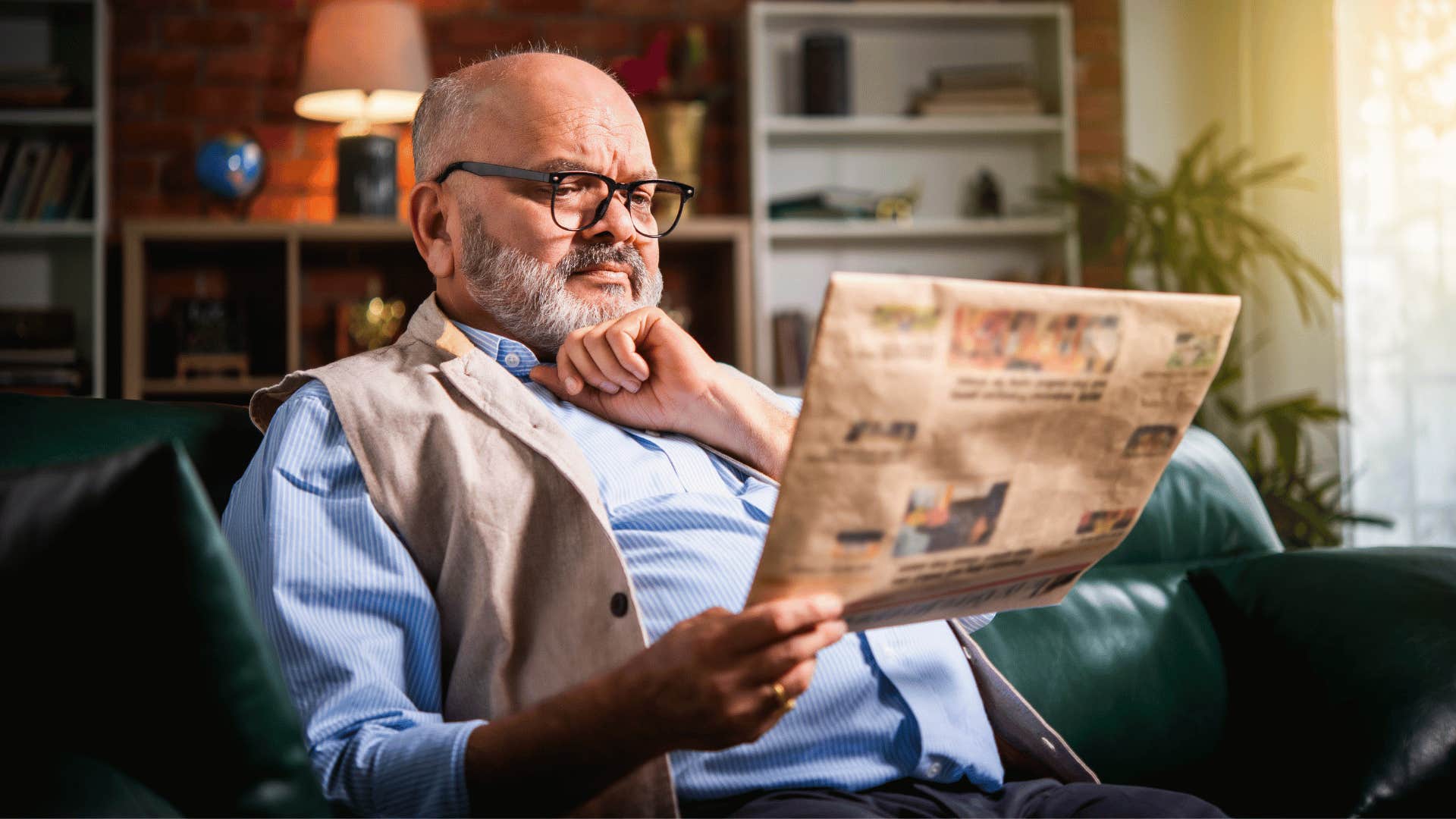 man reading newspaper while sitting down