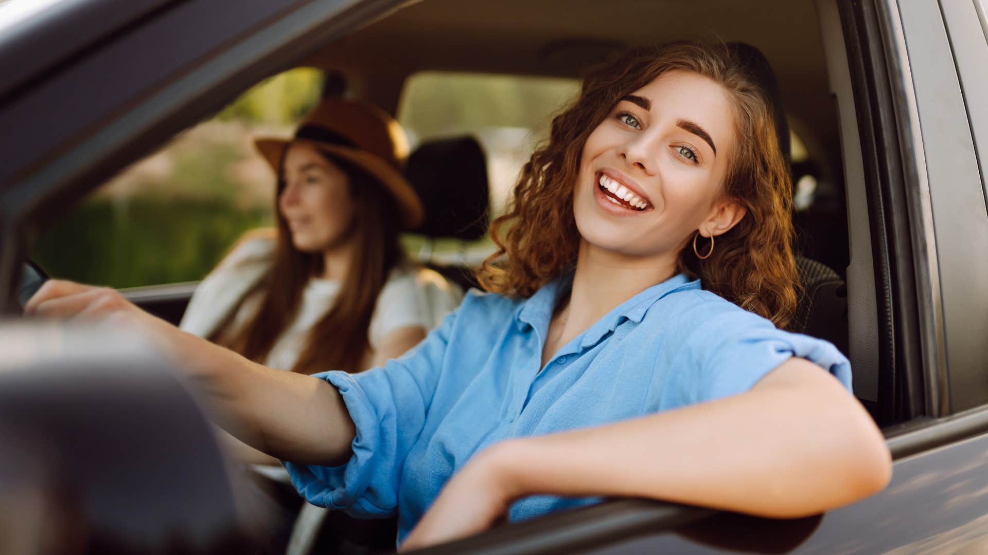 Woman smiling while driving her car.