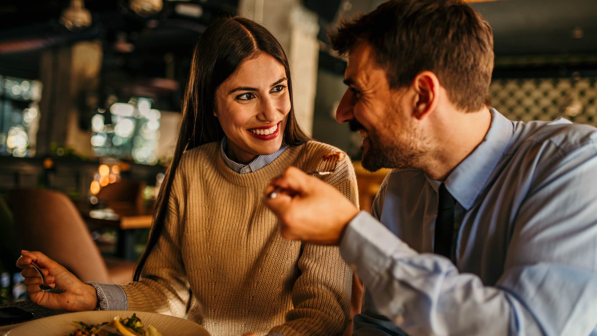 Couple smiling and eating at a restaurant