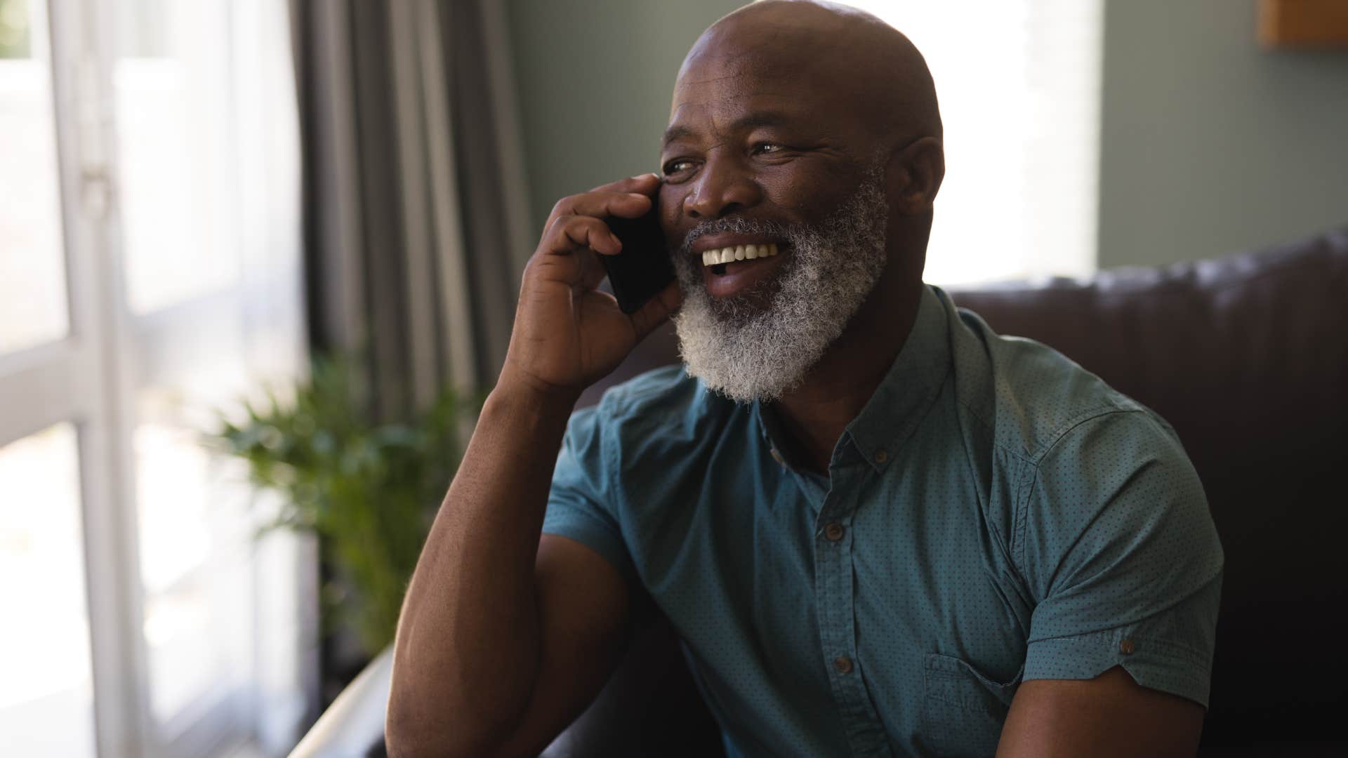 Man smiling while talking on the phone