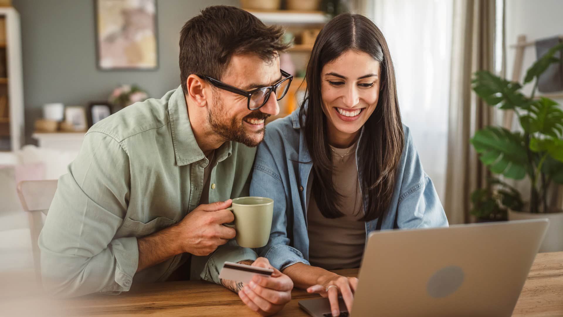 Couple smiling and working on their laptop together