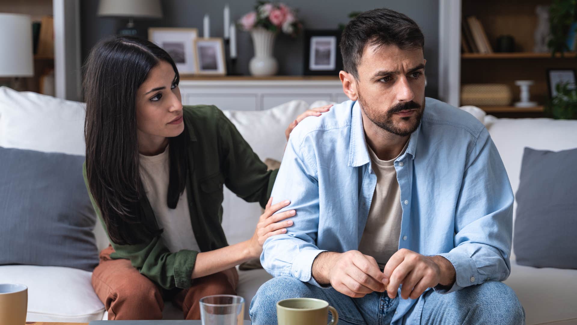 Couple looking upset having an argument on the couch