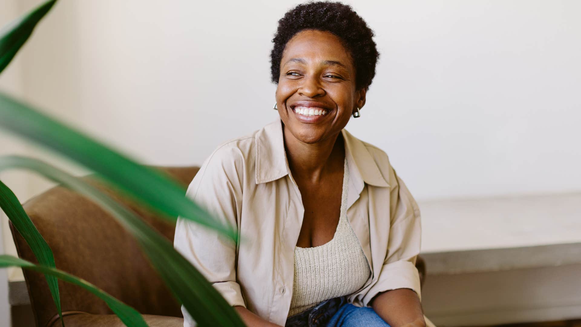 Woman smiling and sitting in a chair. 