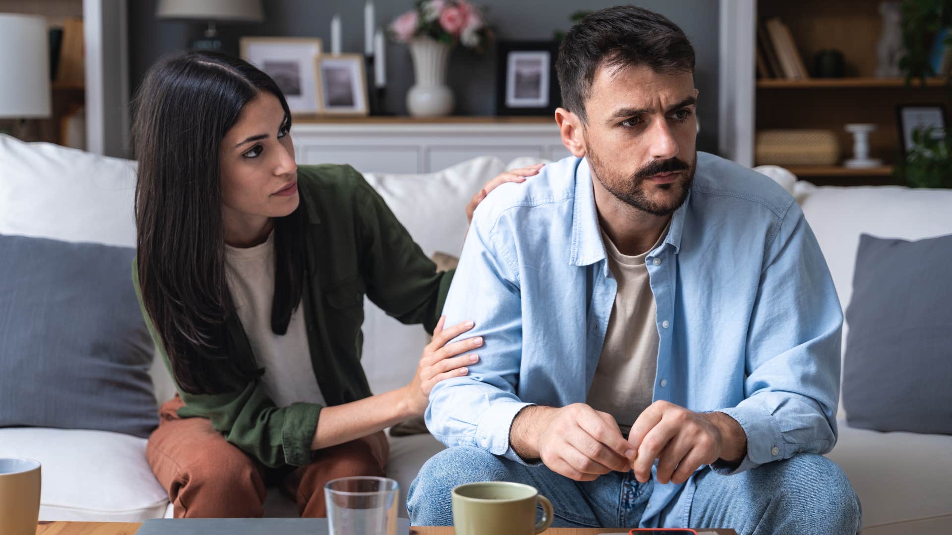 Woman comforting her partner on the couch.