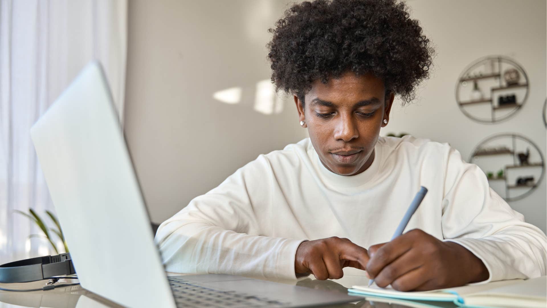 Young man writing seriously in a notebook. 