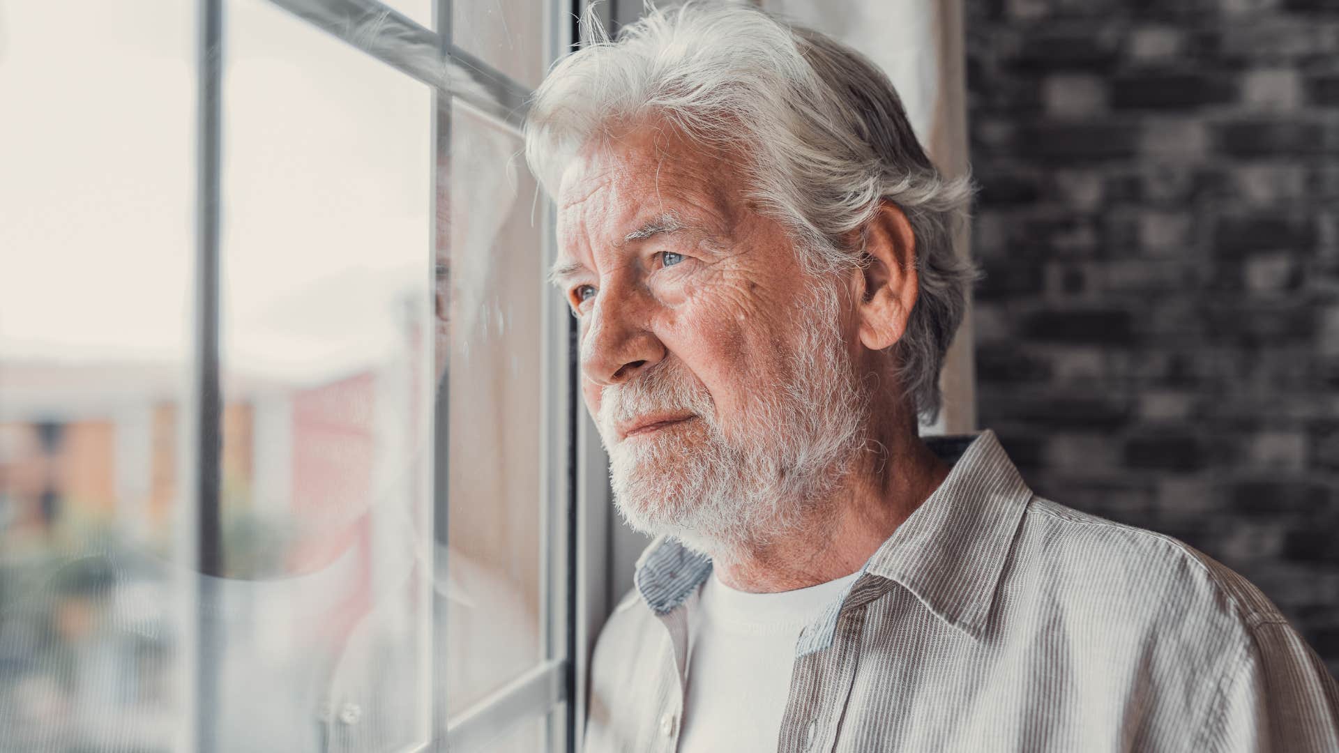 Man looking sad staring out a window