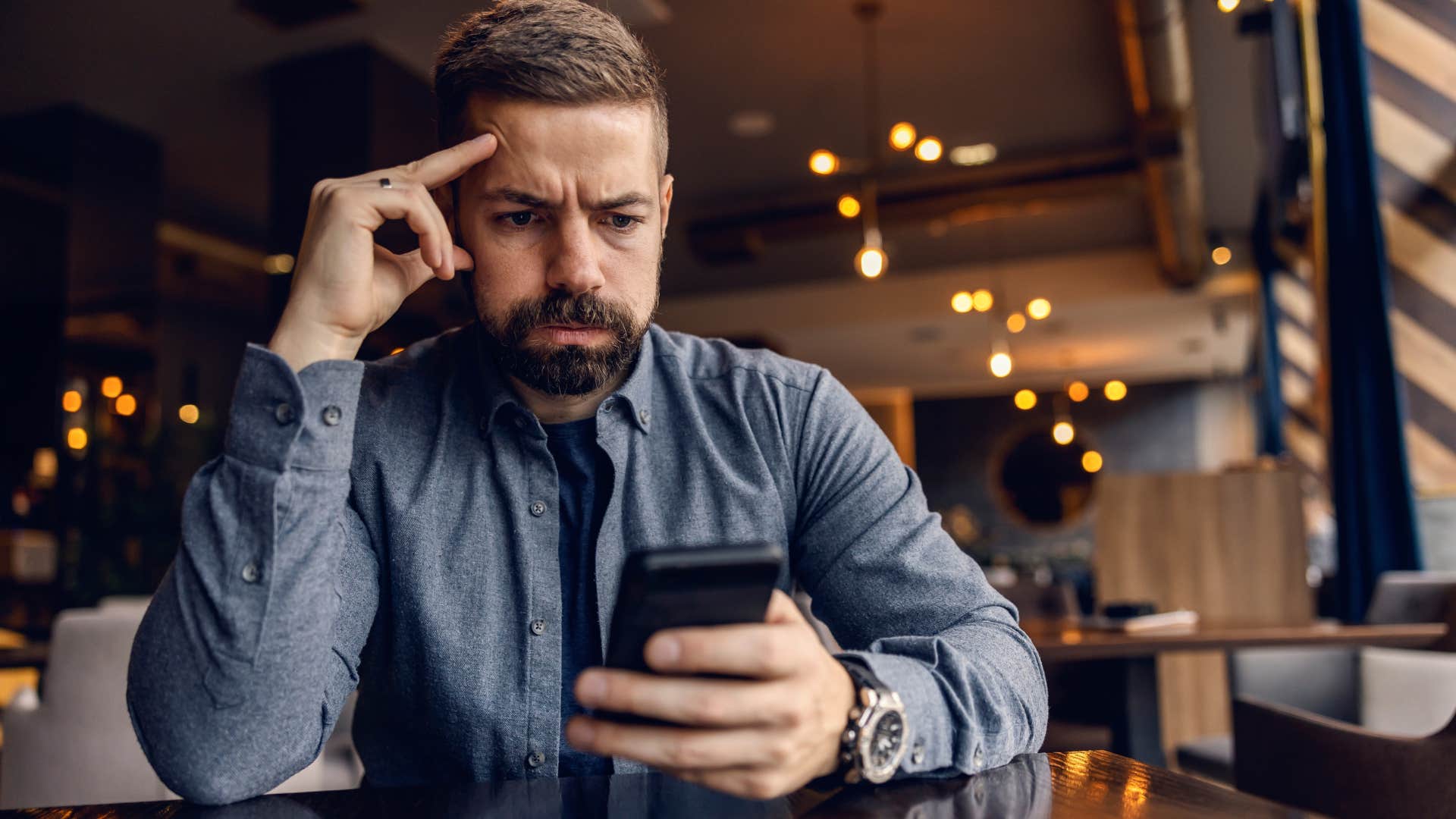 Man looking stressed staring at his phone