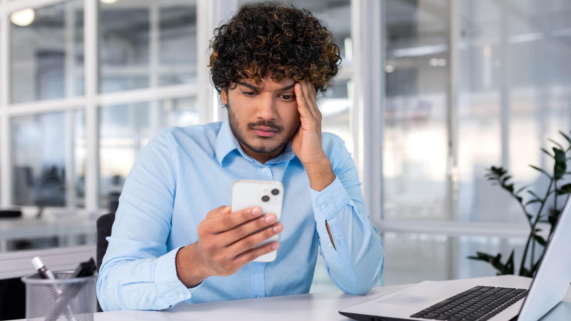 Man looking stressed staring at his phone