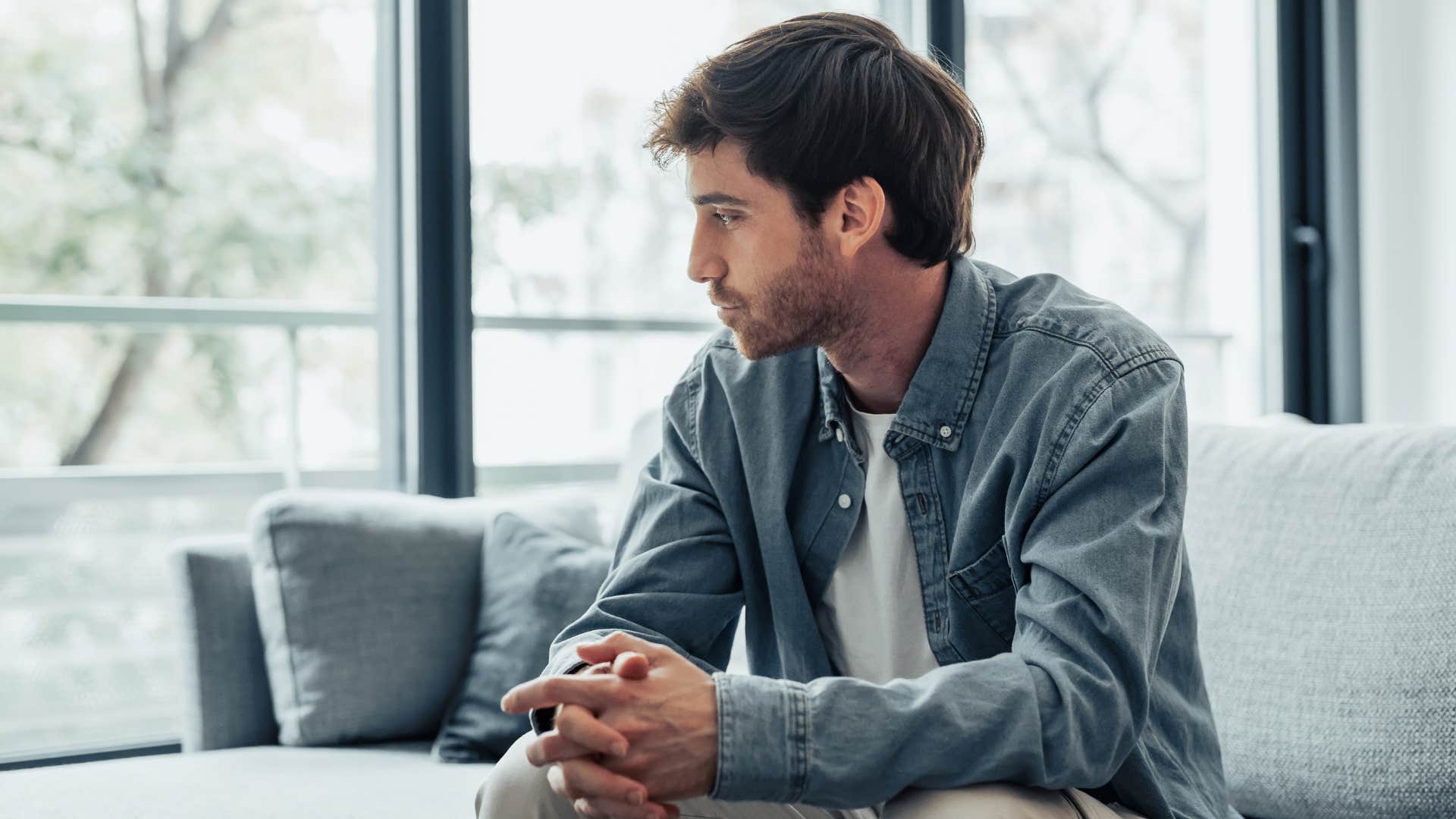 Man looking sad staring out a window