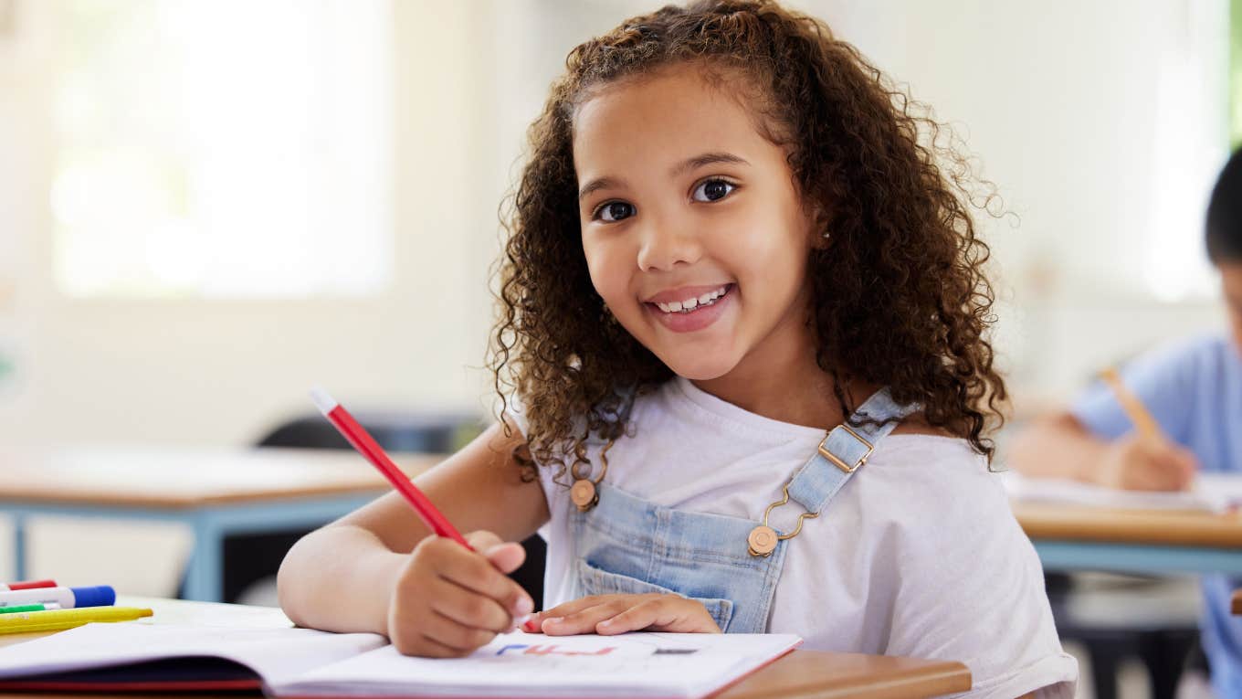 Young smart girl writing at her desk.