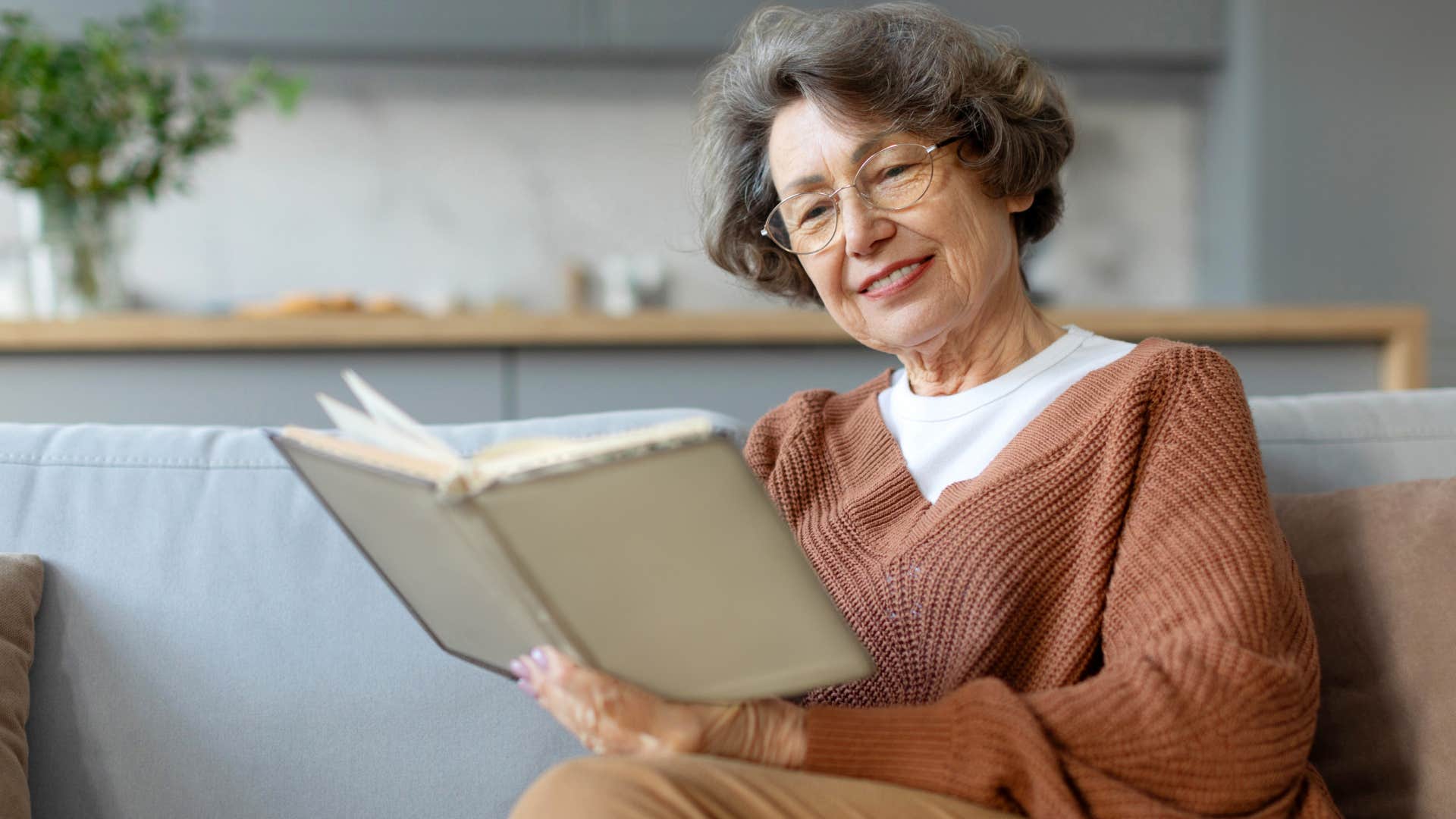 Woman reading a book on her couch