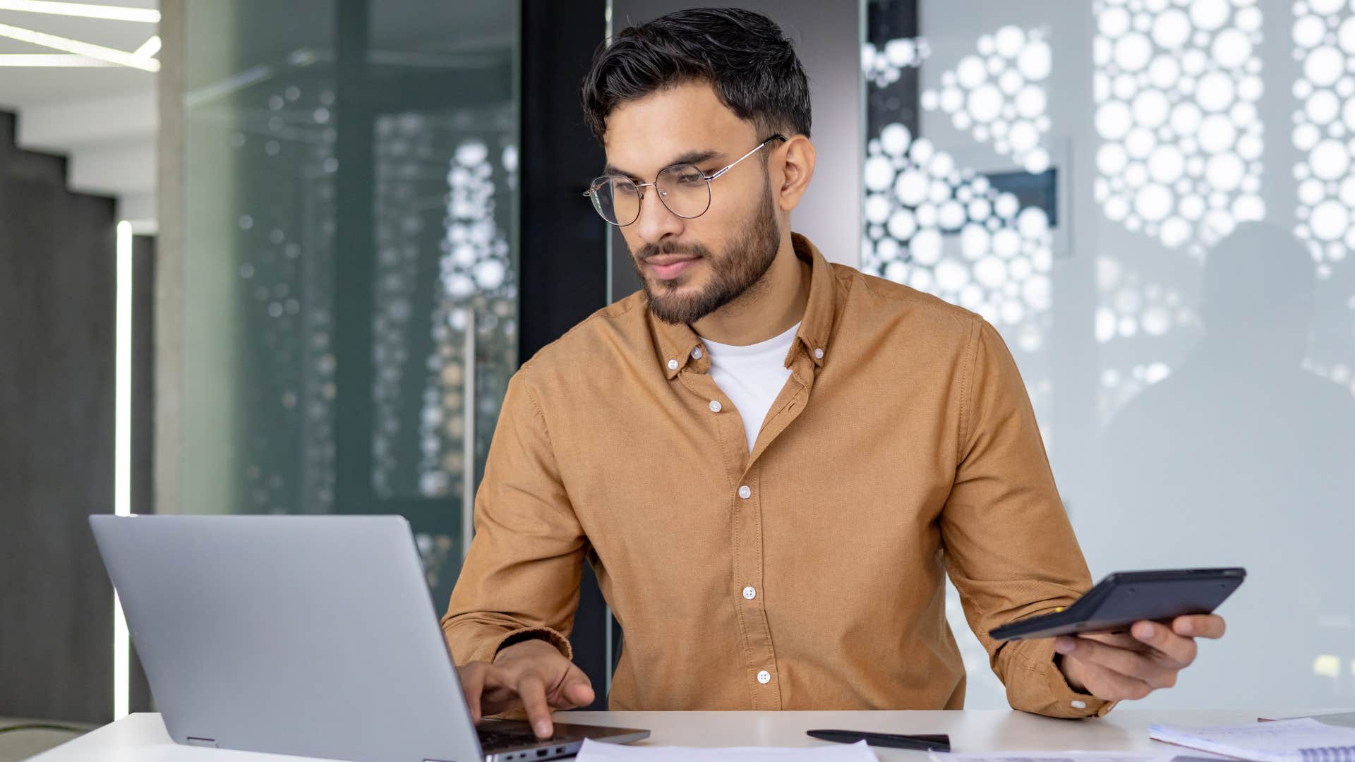 Man working at his desk with a calculator 