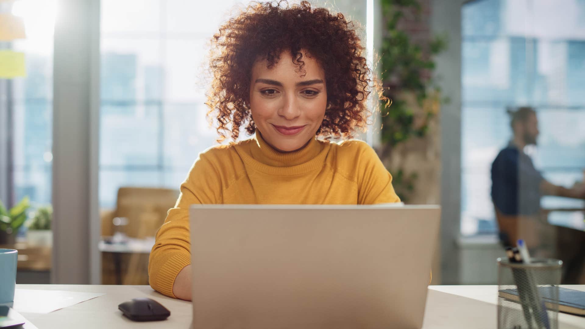 Woman smiling while working on her laptop