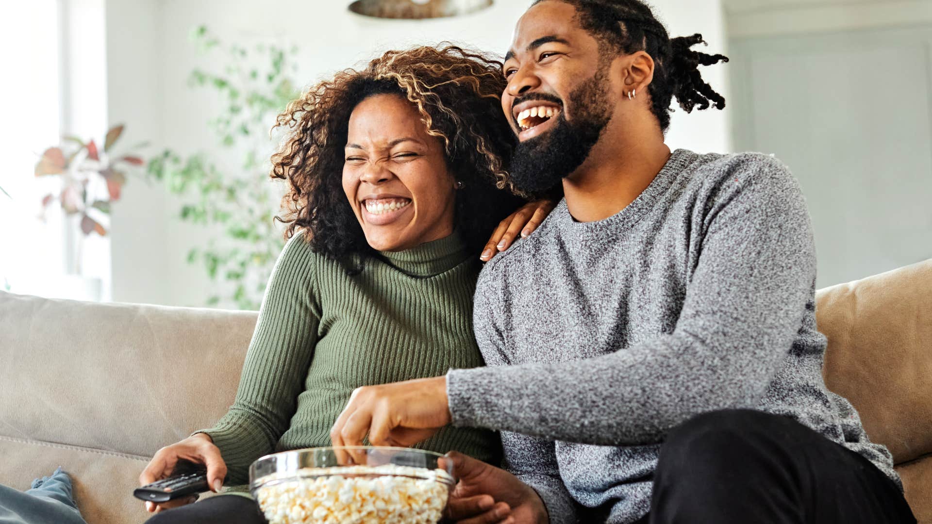 Couple smiling and watching television together