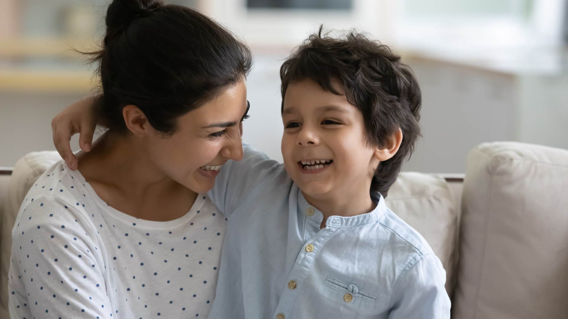 Woman hugging her smiling son.