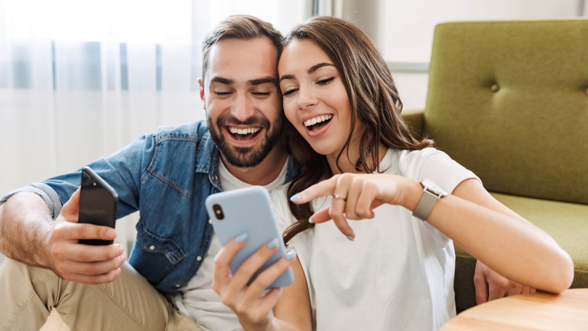 Woman pointing at her phone next to a man.