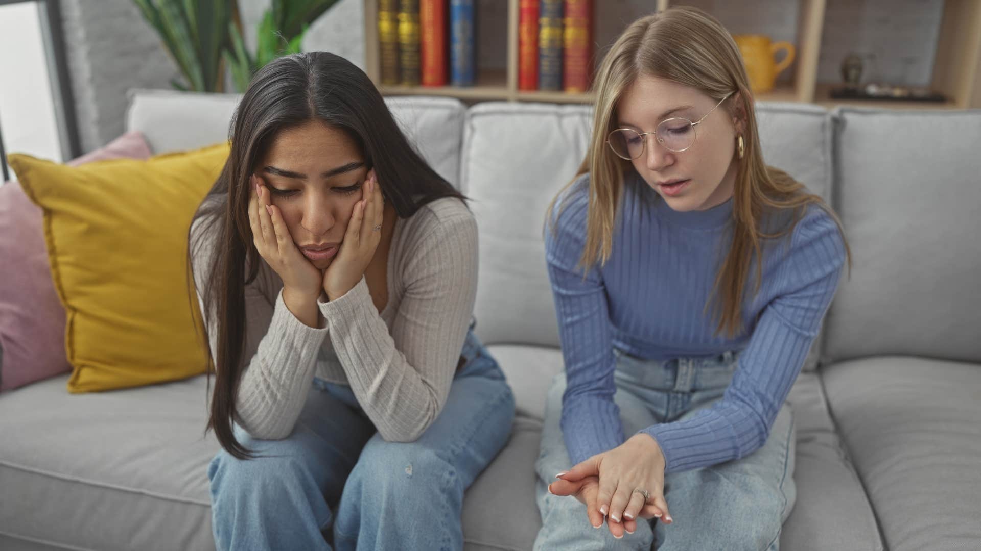 Two women having a serious conversation on the couch.