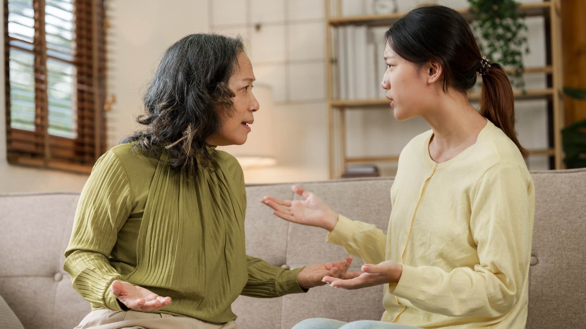 Adult woman arguing with her mother on the couch.