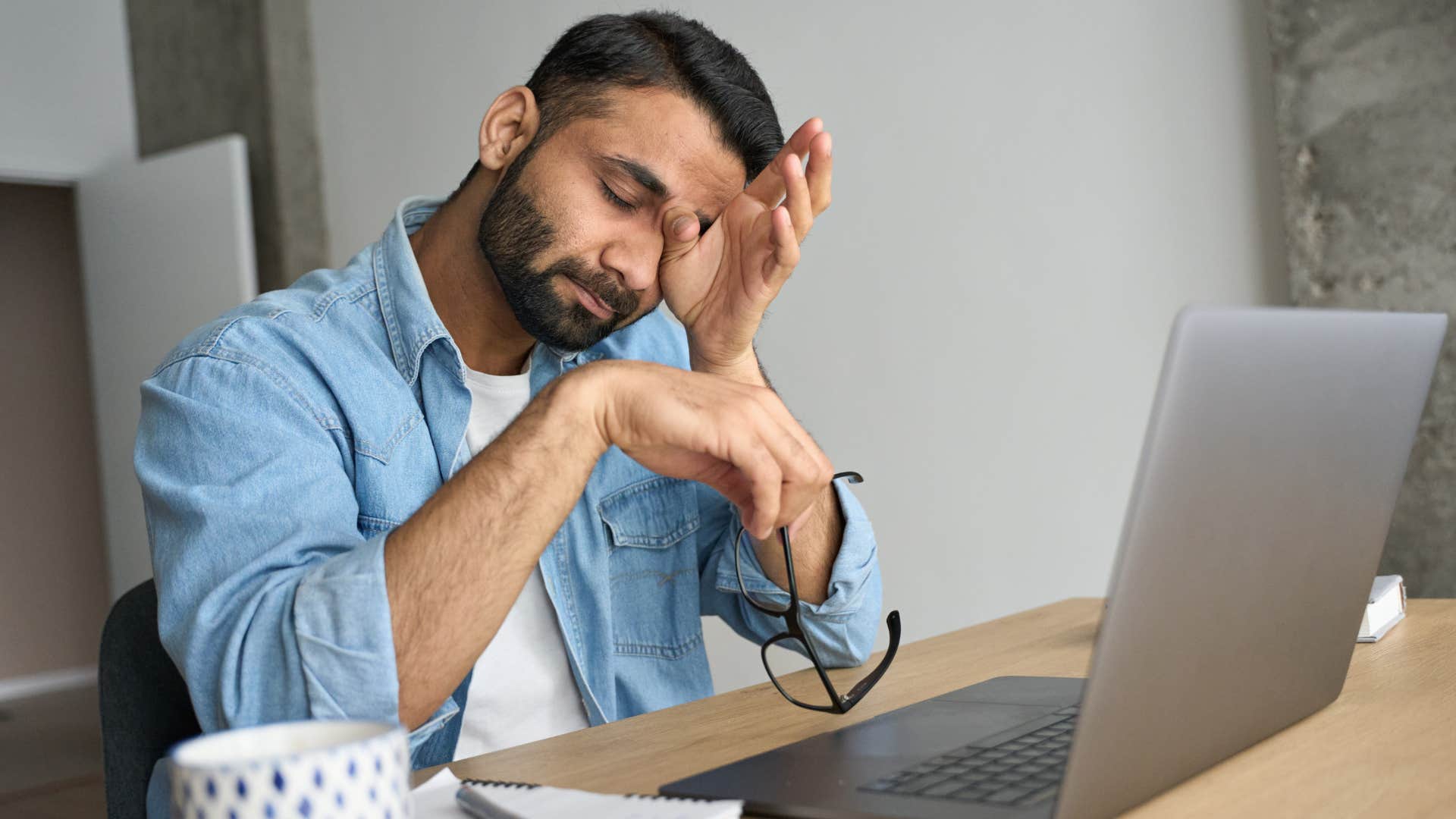 Man looking stressed staring at his laptop. 