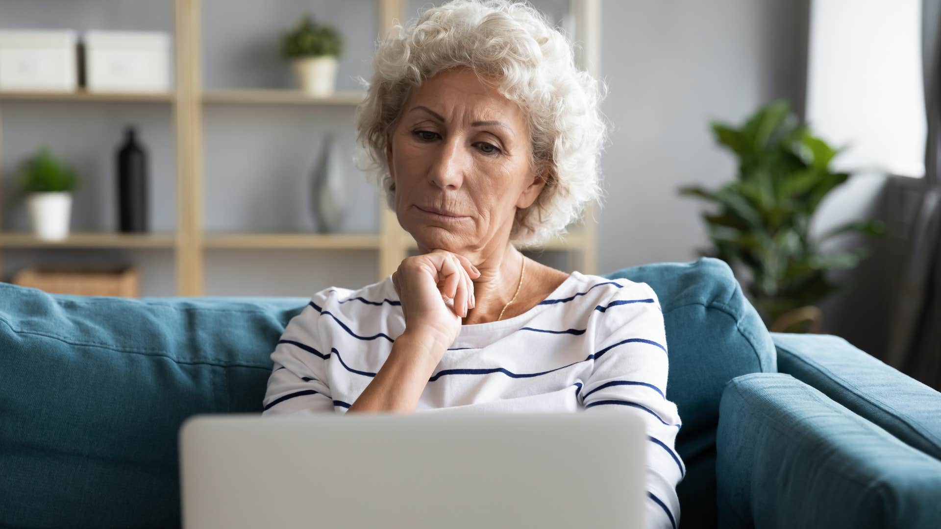 Older woman looking confused staring at her laptop. 